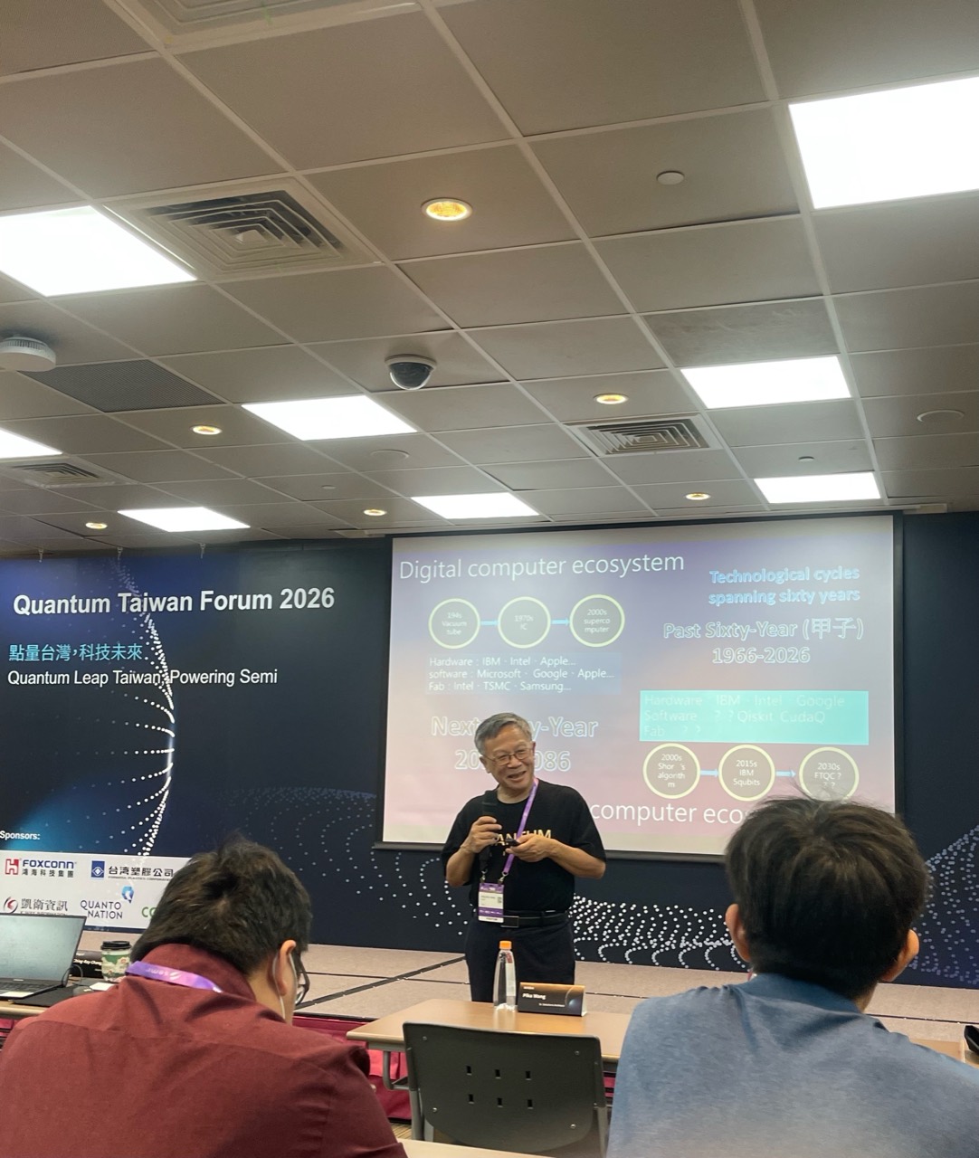 A speaker and audience at QTF 2026 during a presentation on the computing ecosystem
